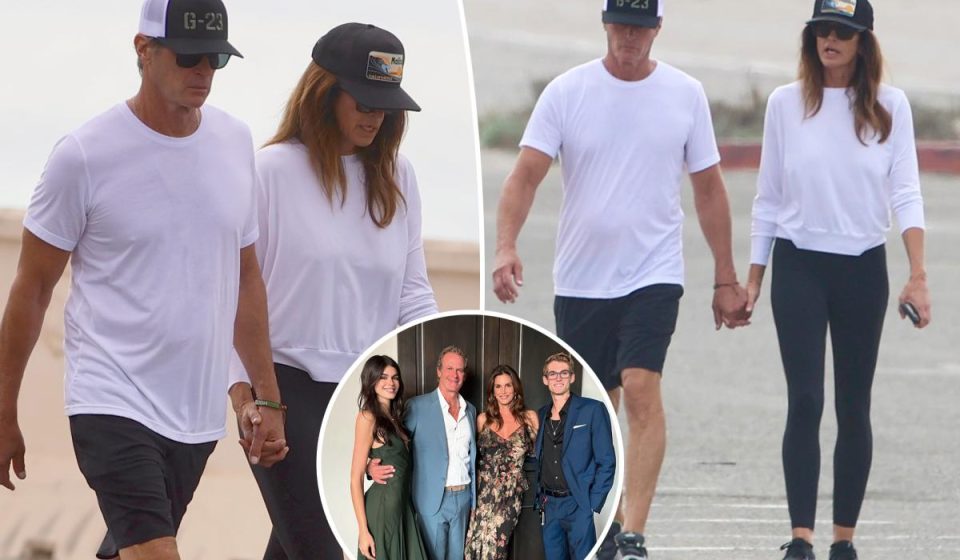 Cindy Crawford and her husband Rande Gerber hold hands during a walk on the beach