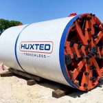 An 8-ton German tunnel boring machine gripped rock so its own cutting wheel couldn't topple it, cut three 51-inch water intakes under a Georgia reservoir and exited three times through the lake bed for divers to recover, over a 35-foot raised dam to more than triple its storage.