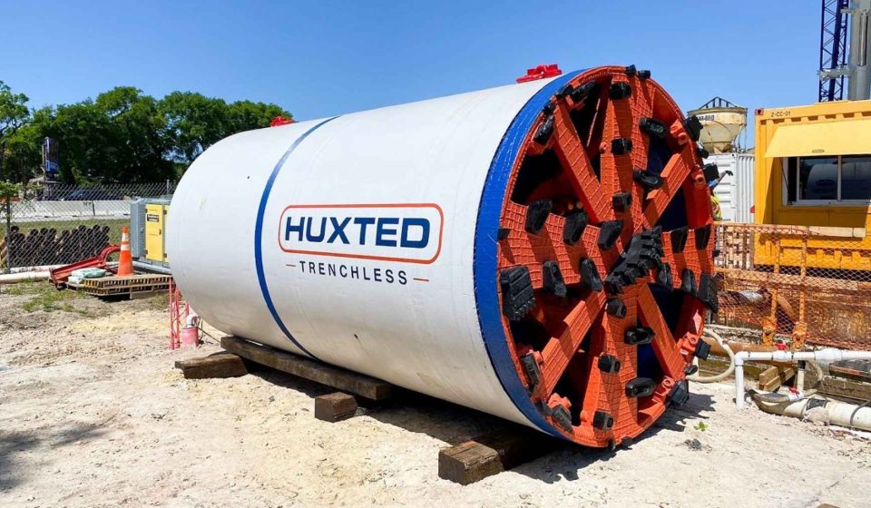 An 8-ton German tunnel boring machine gripped rock so its own cutting wheel couldn't topple it, cut three 51-inch water intakes under a Georgia reservoir and exited three times through the lake bed for divers to recover, over a 35-foot raised dam to more than triple its storage.