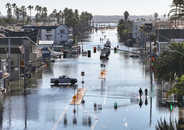 Photos show record high tides flooding homes and roads in Southern California
